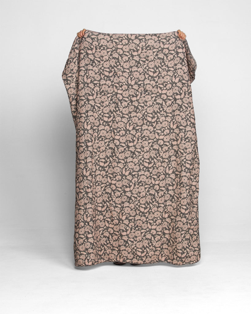 Model holding the Anthracite Flower Sherpa Cottage blanket, displaying the full charcoal and lilac floral print of this cozy Sherpa throw blanket. 