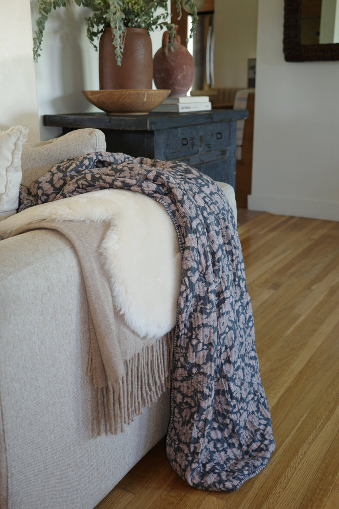 Cozy Anthracite Flower Sherpa Cottage blanket with charcoal and lilac floral design draped over a living room couch, showcasing its plush Sherpa texture and modern home decor style. 