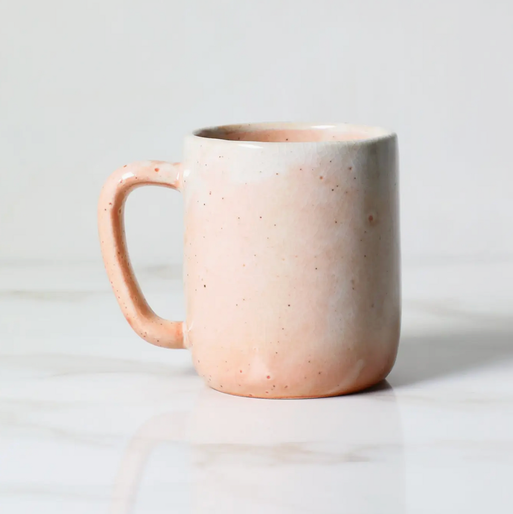 Shino glazed speckled ceramic mug on a light background