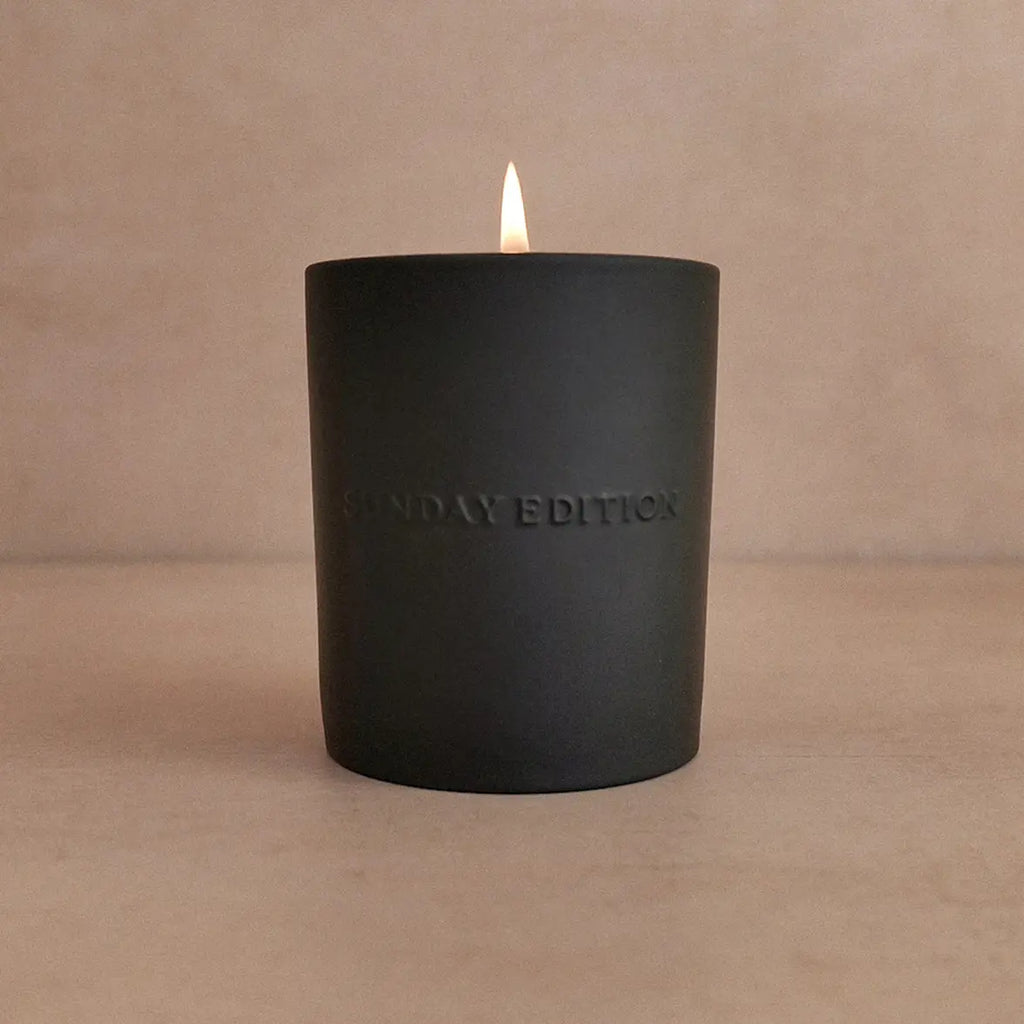 Black candle with 'SUNDAY EDITION' text on a beige background