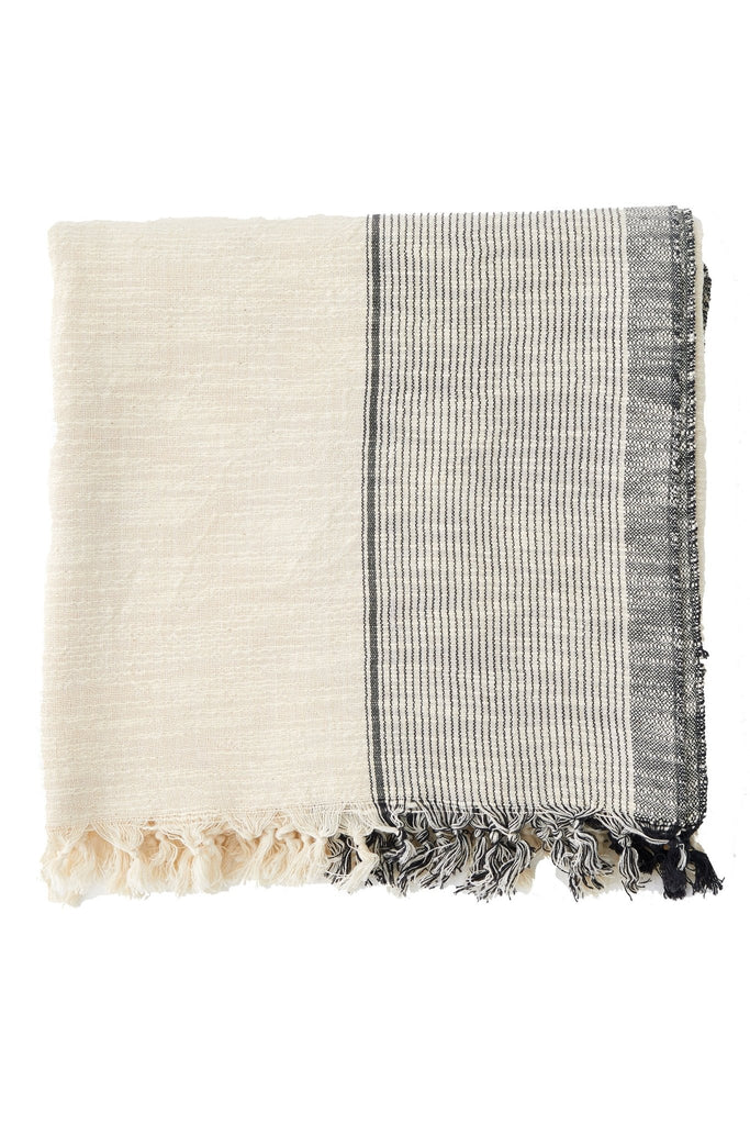 throw blanket with thin grey stripes on the edge , and hand knotted tassels on the edge